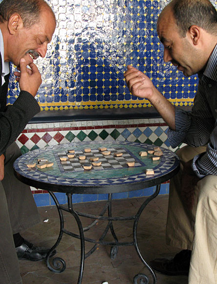 locals playing checkers at a pottery in Fez